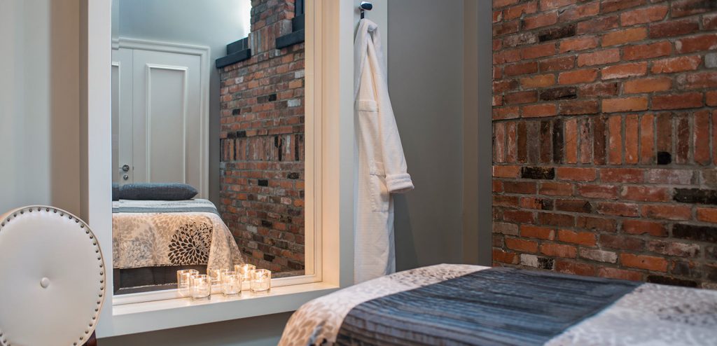 Magnolia Spa treatment room with brick wall, candles and house.