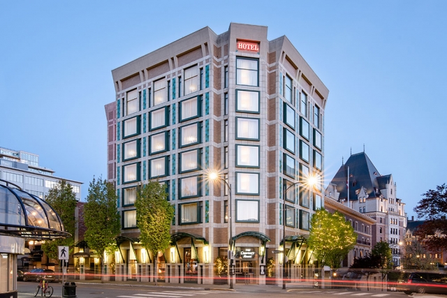 Exterior of hotel & restaurant at dusk with parliament building in background