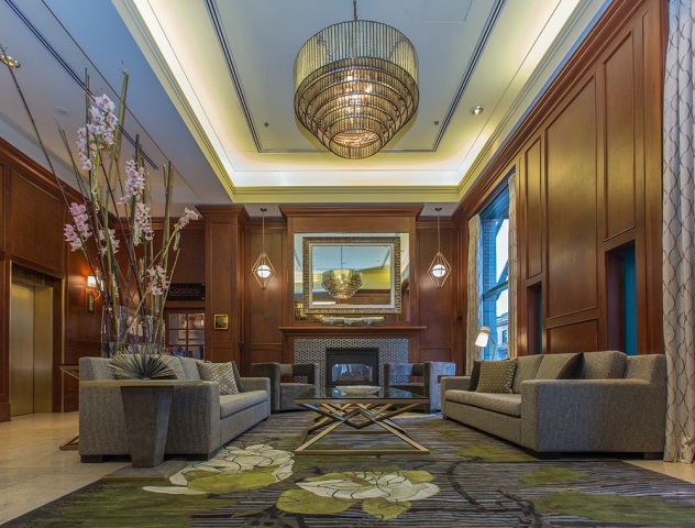 Magnolia Lobby with ornate rugs, modern chandelier and fresh cut tall pink flowers