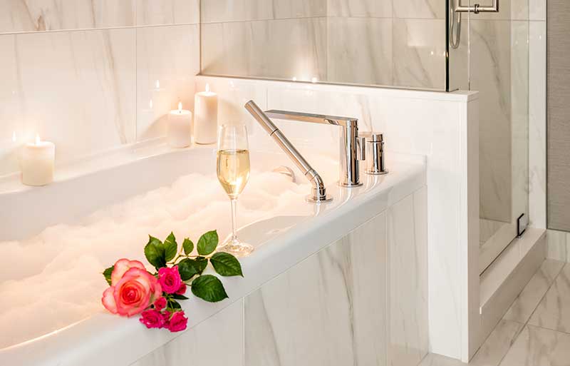 bubble bath with candles, champagne, and roses